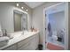 Well-lit bathroom with a large mirror, vanity with storage, and adjacent toilet room, offering convenience and style at 147 Johnston Farm Ln, Woodstock, GA 30188