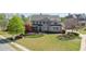 Charming two-story home with lush green lawn, mature trees, and inviting curb appeal at 147 Johnston Farm Ln, Woodstock, GA 30188