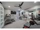 Well-equipped home gym featuring treadmills, stationary bike, TV, mirror, and ceiling fan at 147 Johnston Farm Ln, Woodstock, GA 30188