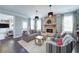 Cozy living room with a brick fireplace, comfortable seating, and ample natural light at 147 Johnston Farm Ln, Woodstock, GA 30188