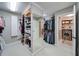 Spacious walk-in closet with custom shelving, mirror and adjoining laundry room, providing ample storage and convenience at 147 Johnston Farm Ln, Woodstock, GA 30188