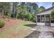 A serene backyard with stone patio, screened porch, and lush greenery, offering a private retreat at 7700 Dunvegan Close, Atlanta, GA 30350