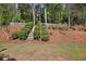 Landscaped backyard with a wooden fence and tiered garden, creating a private and serene outdoor space at 7700 Dunvegan Close, Atlanta, GA 30350