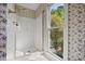 Bright bathroom with a glass-enclosed shower, floral wallpaper, and natural light from a window at 7700 Dunvegan Close, Atlanta, GA 30350