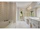 Elegant bathroom featuring a soaking tub, double vanity, floral wallpaper, and ample natural light at 7700 Dunvegan Close, Atlanta, GA 30350