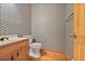 Charming half bathroom with patterned wallpaper, hardwood floors, and a classic vanity at 7700 Dunvegan Close, Atlanta, GA 30350