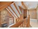 Hallway with wood railing overlooking a living area featuring a fireplace and exposed beams at 7700 Dunvegan Close, Atlanta, GA 30350