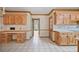 Eat in kitchen featuring light wood cabinets, a desk, and white tile flooring at 7700 Dunvegan Close, Atlanta, GA 30350