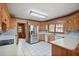 Kitchen with stainless steel appliances, tile backsplash, white countertops, and light wood cabinets at 7700 Dunvegan Close, Atlanta, GA 30350