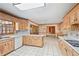 Open floor plan kitchen with white tile floor and light wood cabinets and appliances at 7700 Dunvegan Close, Atlanta, GA 30350