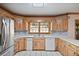 Kitchen with stainless steel fridge, double sink, white appliances, and light wood cabinets at 7700 Dunvegan Close, Atlanta, GA 30350