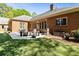 Brick home with a backyard patio for relaxing and outdoor dining, surrounded by manicured lawn and trees at 8518 Shoreview Ct, Jonesboro, GA 30236