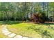 Lush backyard featuring a stone pathway surrounded by trees, providing a serene and private outdoor space at 8518 Shoreview Ct, Jonesboro, GA 30236
