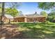 A spacious backyard featuring lush green grass, mature trees, and a charming brick home at 8518 Shoreview Ct, Jonesboro, GA 30236