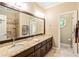 Bathroom with double sinks, granite countertops, large mirror, and a walk-in shower at 8518 Shoreview Ct, Jonesboro, GA 30236