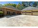 Exterior view of a brick home featuring a three-car garage and an expansive concrete driveway at 8518 Shoreview Ct, Jonesboro, GA 30236