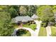 Aerial view of a brick home with mature trees, a circular driveway, and a well-manicured lawn at 8518 Shoreview Ct, Jonesboro, GA 30236