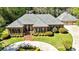 Beautiful brick home with a three car garage, manicured lawn, and a circular driveway at 8518 Shoreview Ct, Jonesboro, GA 30236