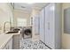 Laundry room with washer, dryer, patterned tile floor, and storage cabinets at 8518 Shoreview Ct, Jonesboro, GA 30236