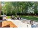 Patio area with chairs and grill looking out to the wooded backyard, perfect for relaxing and entertaining at 8518 Shoreview Ct, Jonesboro, GA 30236