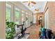 Brick sunroom featuring multiple windows, ceiling fans, and brick flooring at 8518 Shoreview Ct, Jonesboro, GA 30236