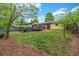 Expansive backyard features green lawn, mature trees, and a large deck perfect for entertaining at 2921 Country Squire Ln, Decatur, GA 30033