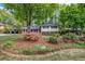 Exterior front yard view of the home showing a lush, manicured landscape with a mature tree and flower bed at 2921 Country Squire Ln, Decatur, GA 30033