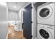 Convenient laundry area with a stacked washer and dryer, located near a hallway and stairs at 2921 Country Squire Ln, Decatur, GA 30033