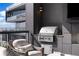 Close-up of the covered balcony featuring a built-in grill, city views, and chair at 3107 Peachtree Ne Rd # 1403, Atlanta, GA 30305