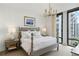 Bright bedroom featuring a gray bed frame, stylish chandelier, and large windows with city views at 3107 Peachtree Ne Rd # 1403, Atlanta, GA 30305
