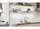 Close-up of the kitchen featuring stainless steel appliances, a sink, countertops, and floating shelves at 3107 Peachtree Ne Rd # 1403, Atlanta, GA 30305