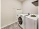 Laundry area with side by side white washer and dryer on a sleek floor at 89 Little Magnolia Ln, Auburn, GA 30011