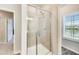 A modern shower with glass door in bathroom features tiled walls and a window view at 89 Little Magnolia Ln, Auburn, GA 30011