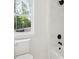 A bathroom features a toilet near a window with views, and a shower with black fixtures and tile at 3975 Clifton Hill Court #7, Cumming, GA 30040