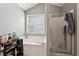 Bathroom featuring a soaking tub, glass enclosed shower, and natural light at 415 Clairidge Sw Ln, Lawrenceville, GA 30046