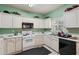 Traditional-style kitchen featuring white cabinets, black appliances, and a light green wall at 415 Clairidge Sw Ln, Lawrenceville, GA 30046