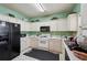 Traditional-style kitchen featuring white cabinets, black appliances, and a light green wall at 415 Clairidge Sw Ln, Lawrenceville, GA 30046