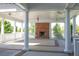 Expansive outdoor patio with a brick fireplace, ceiling fans, and elegant columns at 308 Jessica Way, Canton, GA 30114