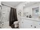 Modern bathroom featuring a white vanity, dark fixtures, and a shower with a black curtain at 3638 Silvery Way, Powder Springs, GA 30127