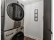 Laundry room with stacked stainless steel washer and dryer, featuring framed wall art at 3638 Silvery Way, Powder Springs, GA 30127