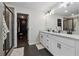 Modern main bathroom featuring double sinks, white cabinets, and a walk-in closet at 3638 Silvery Way, Powder Springs, GA 30127