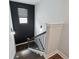A modern staircase with dark wood steps, black railings, and a large window at 3638 Silvery Way, Powder Springs, GA 30127