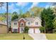 Charming two-story home featuring a brick and siding exterior, a two-car garage, and a well-maintained lawn with beautiful trees at 577 Mountain Oaks Pkwy, Stone Mountain, GA 30087