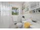 Bright bathroom with a window view, classic white tile, and traditional fixtures at 690 Manor Ridge Sw Dr, Mableton, GA 30126