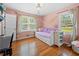 Bright bedroom with hardwood floors, multiple windows, and charming decor at 690 Manor Ridge Sw Dr, Mableton, GA 30126