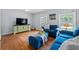 Comfortable living room featuring hardwood floors, cozy blue seating, and bright, natural light at 690 Manor Ridge Sw Dr, Mableton, GA 30126