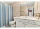 Cozy bathroom featuring a single sink vanity and a toilet with a blue and white striped shower curtain at 104 Lumby Ln, Stockbridge, GA 30281