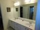 Bright bathroom featuring double sinks, large mirror, and white cabinetry for ample storage at 104 Lumby Ln, Stockbridge, GA 30281