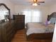 Comfortable bedroom boasts wood floors, a full bed, and classic furnishings with white curtains at 104 Lumby Ln, Stockbridge, GA 30281