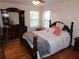 Inviting bedroom with hardwood floors, dresser, and a comfortable bed bathed in natural light at 104 Lumby Ln, Stockbridge, GA 30281